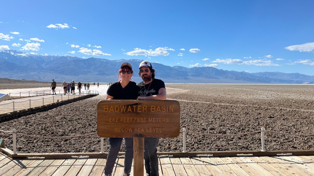 jenn and brian standing behind the Badwater Basin sign.
