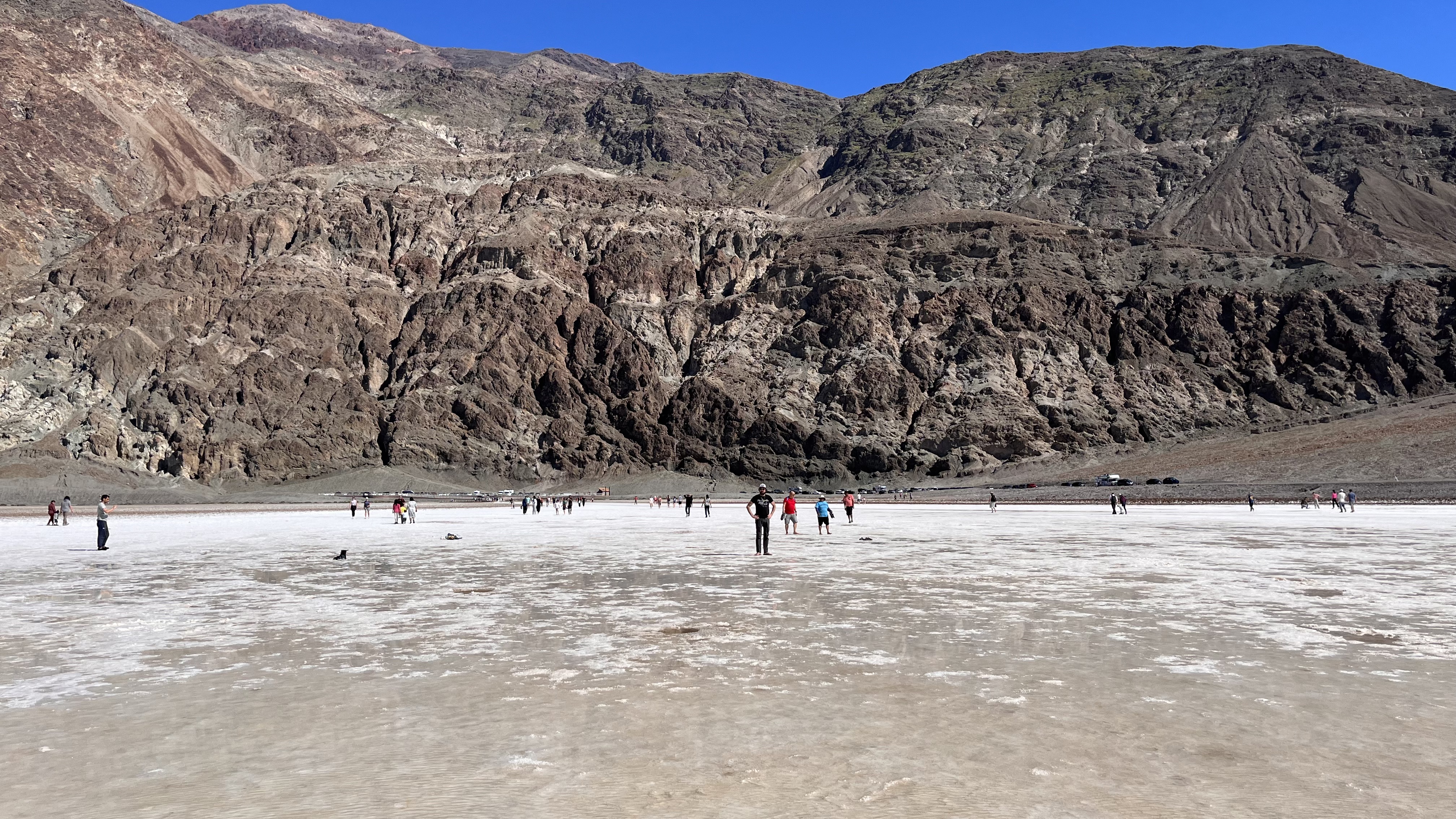 brian standing in the salt with a rocky hill behind him